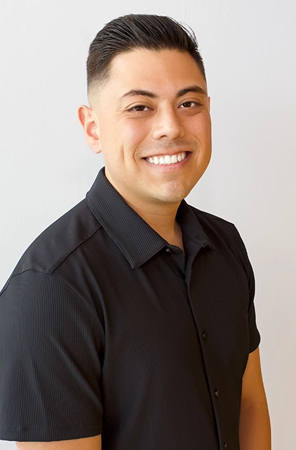 A man in black shirt smiling for the camera.